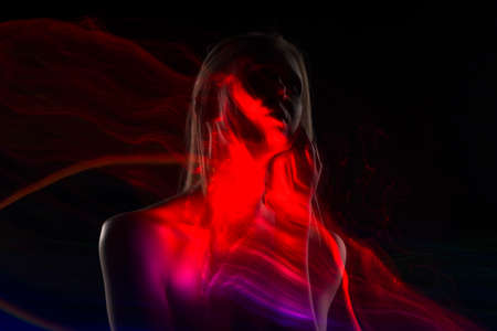 Conceptual avant-garde silhouette portrait of a beautiful blonde girl covered with multicolored lines applied by a lightbrush. Art photo.Copy space. Advertising, fashion and commercial Designの写真素材