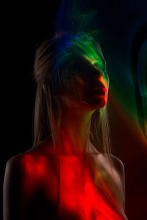 Conceptual avant-garde silhouette portrait of a beautiful blonde girl covered with multicolored lines applied by a lightbrush. Art photo.Copy space. Advertising, fashion and commercial Designの写真素材