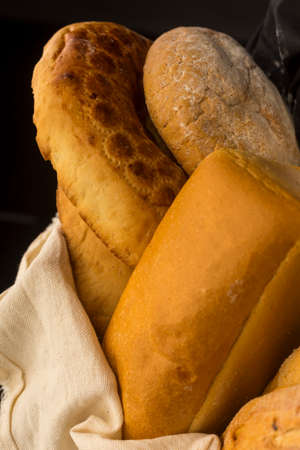 Conceptual still life art photography of a different kinds of bread wrapped in white cloth on an...
