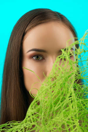 Beautiful naked shoulders young girl wearing green grass type veil mesh on her face covers her...