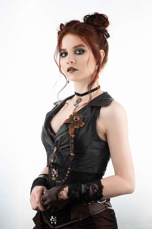 A beautiful redhead cosplayer girl wearing a Victorian-style steampunk costume with big breasts in a deep neckline. Isolated on white. Copy space.の写真素材
