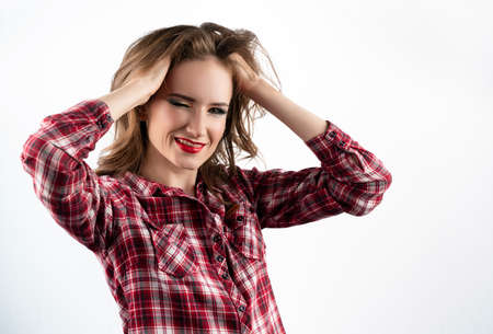 Beautiful emotional girl model with red lips make-up, wearing a casual plaid shirt and jeans  winks...