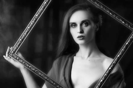 Beautiful girl with trendy makeup, wearing a silk scarf thrown over her shoulders that covers her...