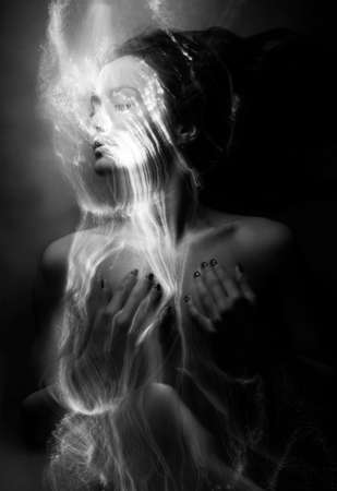 Conceptual monochrome black and white avant-garde portrait of a beautiful young girl covered with lines applied by a light brush. Art style creative photo. Advertising, fashion and commercial designの写真素材