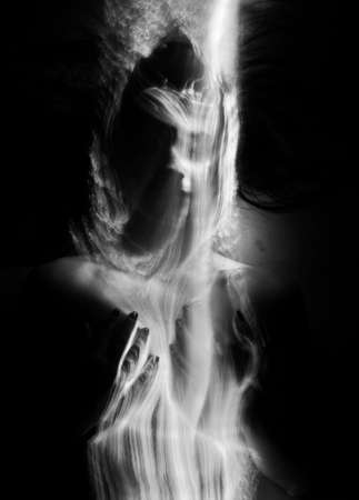 Conceptual monochrome black and white avant-garde portrait of a beautiful young girl covered with lines applied by a light brush. Art style creative photo. Advertising, fashion and commercial designの写真素材
