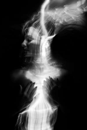 Conceptual monochrome black and white avant-garde portrait of a beautiful young girl covered with...