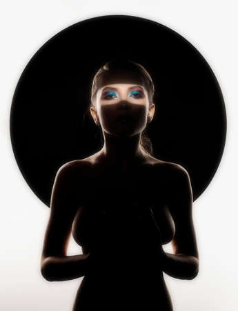 Beautiful topless busty girl poses at the black circle. Her breast and face is hide in the deep shadows and seen only silhouette of her body and her eyes. Isolated on white. Artistic designの写真素材
