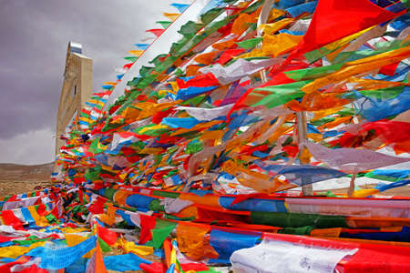 Tibetan praying flags against the Himalaya Mountains and a grey sky.の写真素材