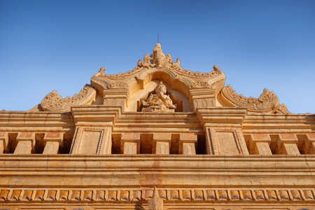 Blue sky above an ancient temple carved with religious motifs in old Bagan, Myanmar.の写真素材