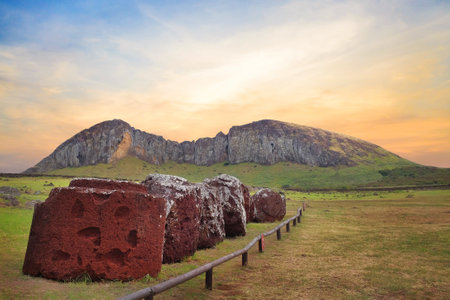 Moai head parts at the Ahu Tongariki ceremonial center on Easter Island, against a colorful sunset sky.の写真素材