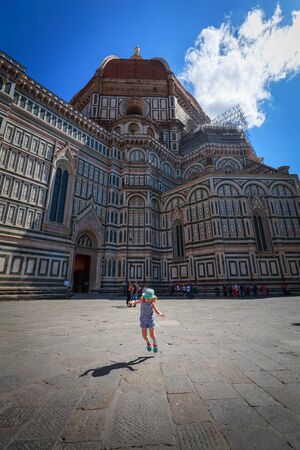 Florence, Italy - June 15, 2018: Sightseeing of Florence. Little girl jumping on The Florence Cathedral background. Beautiful destination of Italy. Florence.のeditorial素材