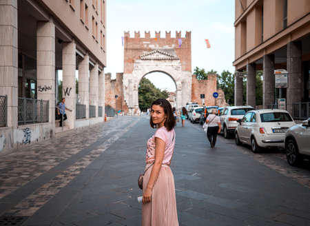 Rimini, Italy - June 11, 2018: Attractive girl on Rimini street turned to camera. Famous destination...