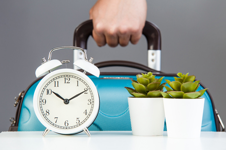 Alarm clock and suitcase. Time to travel. Vacation trip concept.の写真素材