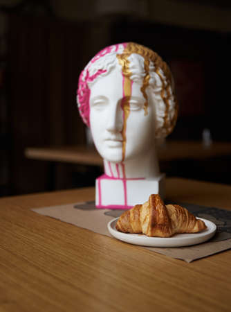 croissant and sculpture on the table in the cafe