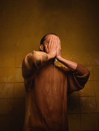 Brutal man in the bathroom in contrast light