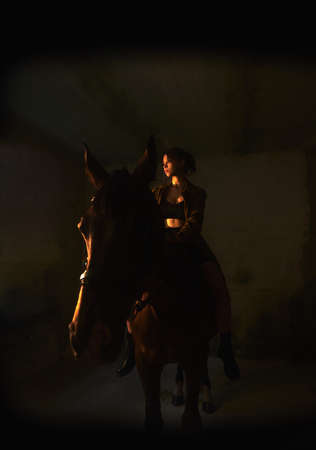 The girl on the horse in the dark roomの写真素材