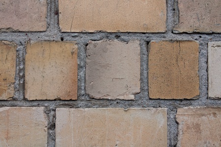 beige and brown brick wall close-up with scratchesの写真素材