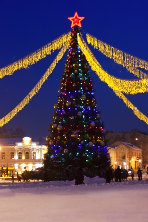 Christmas tree with toys and lights at night on the streetsの写真素材