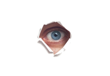 Human eye, seen through a hole in the wall isolated