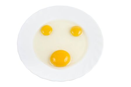Three raw egg yolk on the plate isolatedの写真素材