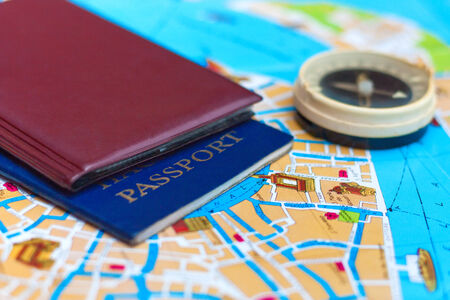 Passport and compass on a map, preparing to travel