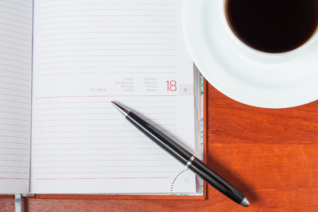 Diary on the table and a cup of coffee. Top viewの写真素材