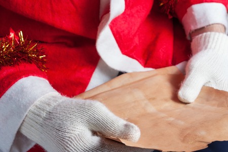 Santa Claus holding sheet of paper and readingの写真素材