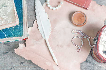 Retro still life with casket, old papers and books on a wooden table. Top view