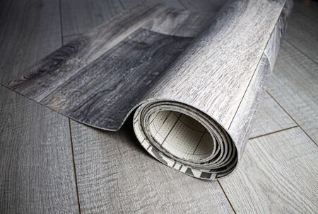 Roll of linoleum with a wood texture. Linoleum cutting. Floor coverings.の写真素材