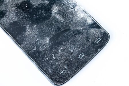 Old broken mobile phone on a white background.