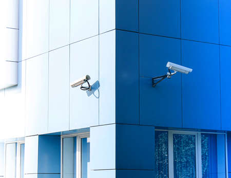 The surveillance cameras on the building are deployed in opposite directions.