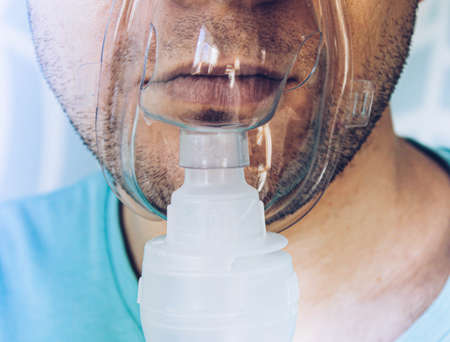A man with an inhalation mask on his face.