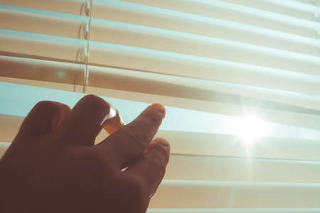 The sun shines through the half-open blinds on the window.の写真素材
