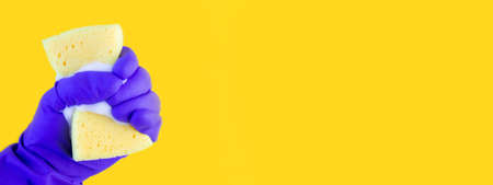 Hand in a rubber glove for cleaning. Kitchen sponge in hand.の写真素材