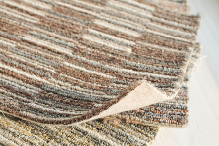 Texture of carpet floor close-up. Brown carpet with a pattern. Geometric shapes on the carpet.