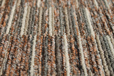 Texture of carpet floor close-up. Brown carpet with a pattern. Geometric shapes on the carpet.