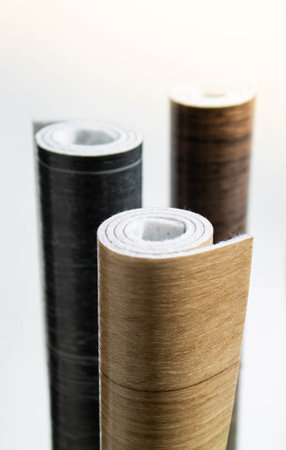 Linoleum. Three rolls of linoleum on a white background. Floor coverings for home use. Linoleum design in the form of boards.の写真素材