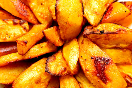 Fried fries and tomato sauce on a yellow background. Fast food. Rustic potatoes baked in the oven. Sliced and fried potatoes.の写真素材