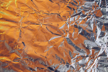 Crumpled foil texture. Crumpled paper is shiny with a color tint.の写真素材