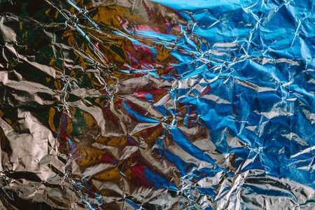 Crumpled foil texture. Crumpled paper is shiny with a color tint.