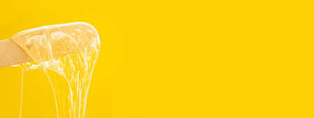 Shugaring paste. Body hair removal. Depilation. The paste drips off the sugaring spatula. Body care products.の写真素材