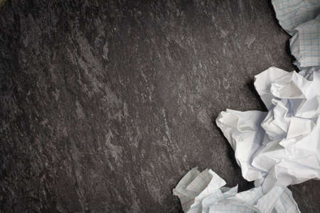 Crumpled and torn paper on the table. Torn piece of notebook. Paper trash. Full basket of notes. Notepad and pencil on crumpled paper background.の写真素材