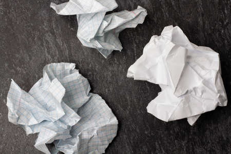 Crumpled and torn paper on the table. Torn piece of notebook. Paper trash. Full basket of notes. Notepad and pencil on crumpled paper background.の写真素材