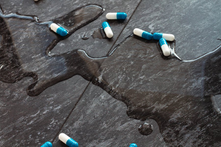 Tablets. Water is spilled and medical capsules are scattered. Ambulance. Pill poisoning. Dropping pills and a glass of water from the hands.の写真素材