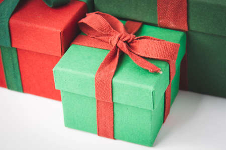 present. Gift box with a bow. New Year's surprise. Red and green box with a gift. On a white background, top view. close-up. Tied with a beautiful ribbon for gifting. under the tree.の写真素材