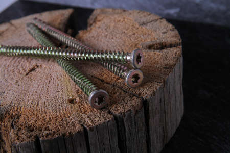 Fasteners for wood. Self-tapping screws on a wooden table.