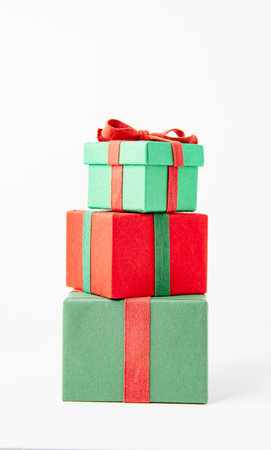 present. Gift box with a bow. New Year's surprise. Red and green box with a gift. On a white background, top view. close-up. Tied with a beautiful ribbon for gifting. under the tree.の写真素材