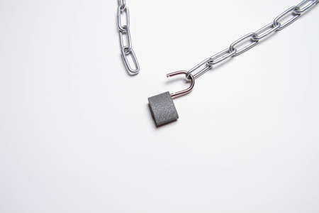 Chain and padlock on an isolated background. A locked padlock hangs on a chain. closed door. secret room. metal chain.の写真素材