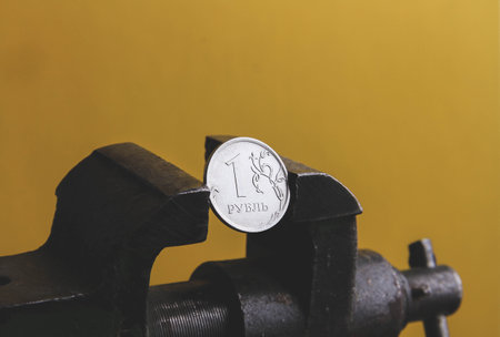 Coin in a vice. The collapse of the ruble. Falling exchange rates. The pressure of sanctions. Blocking payment in rubles.の写真素材