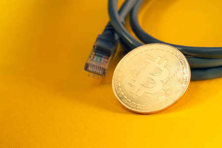 Internet payment for bitcoins. Internet cable and coin. Cryptocurrency as a means of payment. Bitcoin coin close up.の写真素材